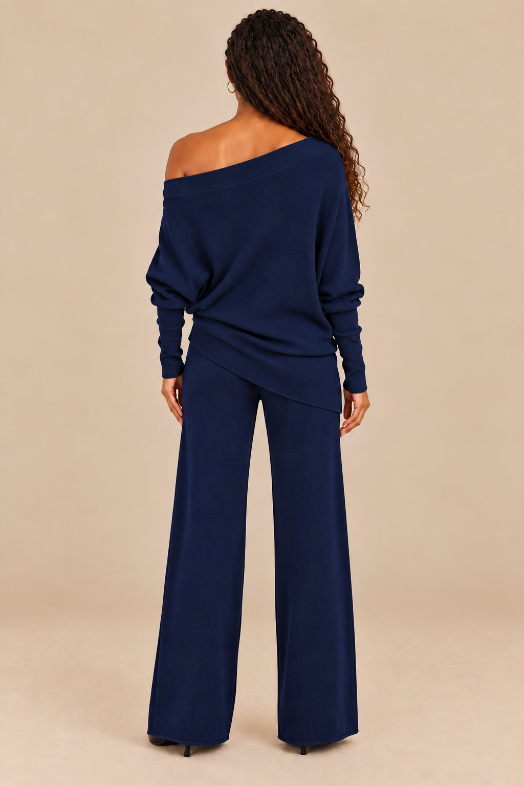 Cassie Navy asymmetrical drape sweater back on campaign model with navy pants