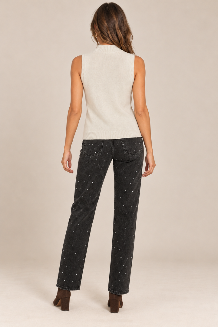Sleeveless Knit Mock Neck Top in Beige — back view on holiday campaign model, rhinestone black jeans and chocolate boots, light tan studio.