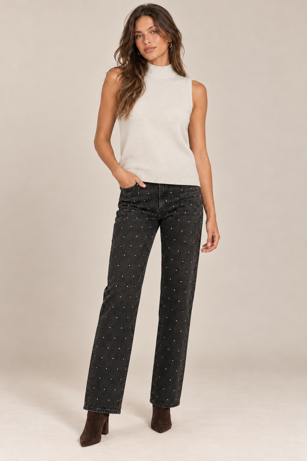Sleeveless Knit Mock Neck Top in Beige — front view on holiday campaign model, rhinestone black jeans and chocolate boots, light tan studio.