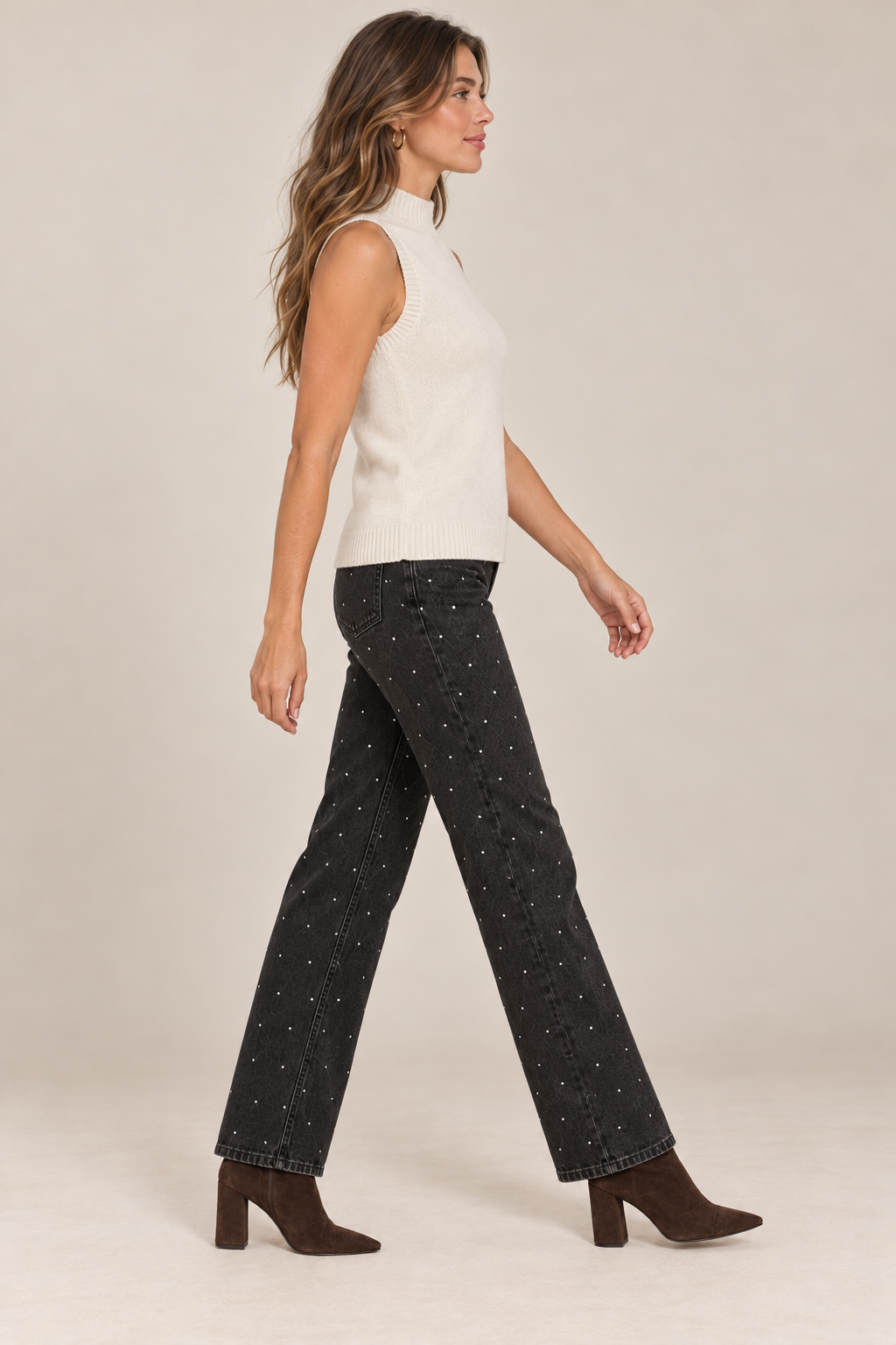 Sleeveless Knit Mock Neck Top in Beige — side view on holiday campaign model, rhinestone black jeans and chocolate boots, light tan studio.