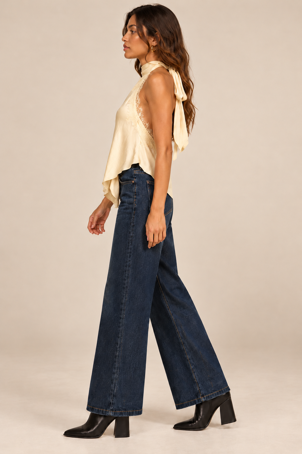Nora Lace Trim Halter Top in Butter — side view on holiday campaign model, jeans and black ankle boots, light tan studio.
